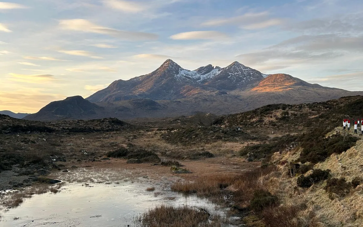 Le frastagliate cime Cuillin sopra uno stagno di brughiera a Skye