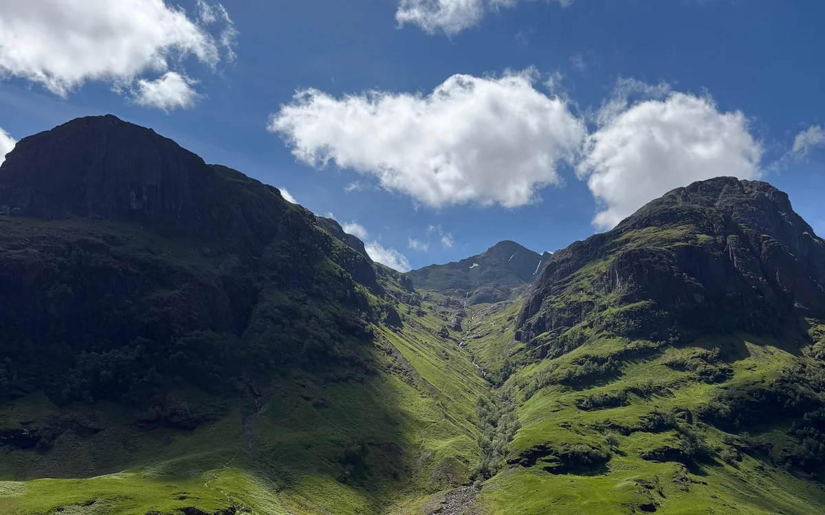 Vette verdi ripide che si innalzano su entrambi i lati di una valle a Glencoe