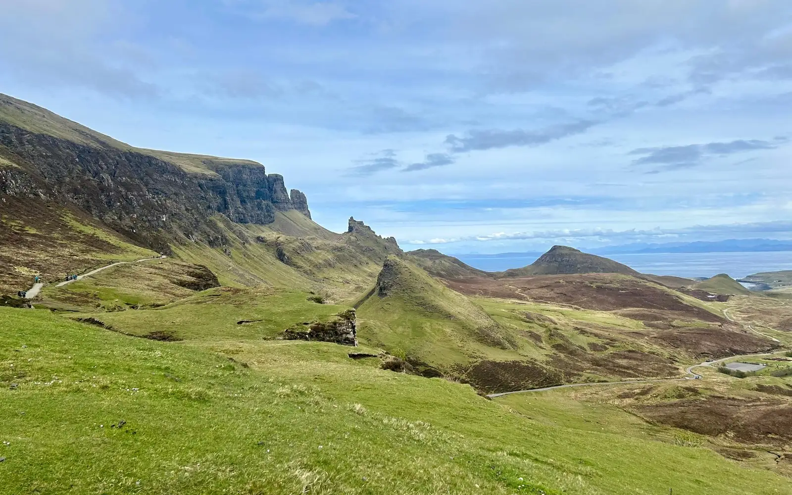 Pendii verdi e guglie rocciose del Quiraing sull'Isola di Skye, con il mare all'orizzonte